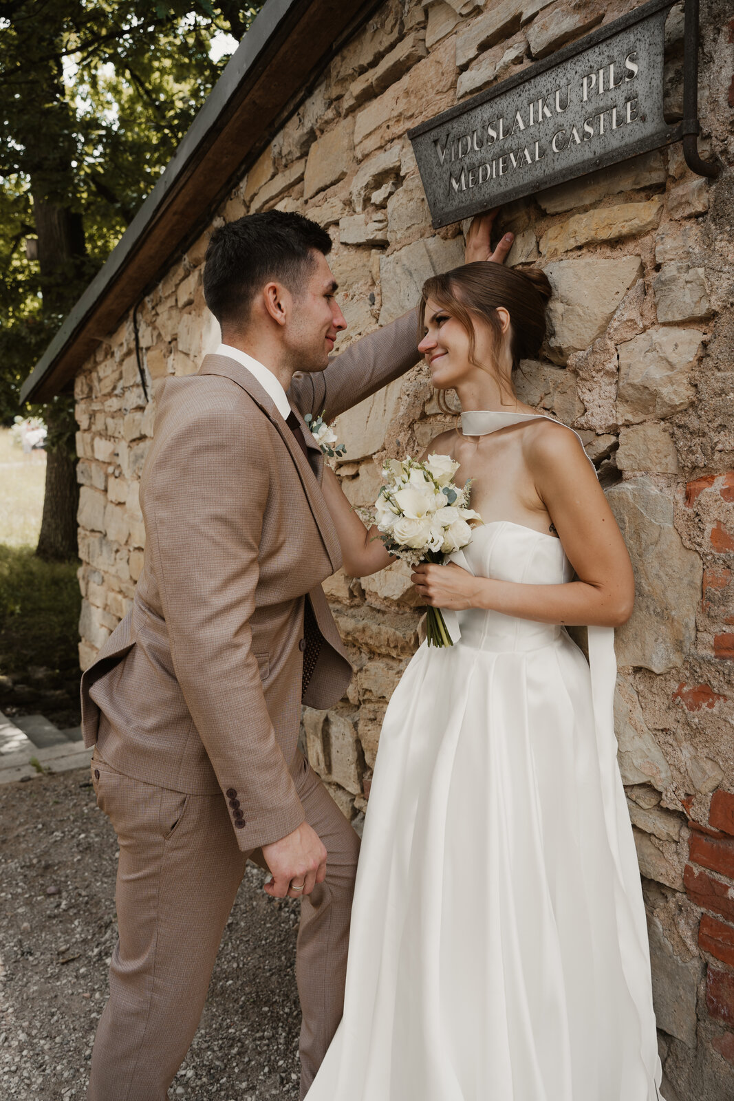 Wedding reportage in Latvia — couple by the wall
